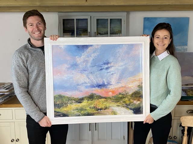 A couple holding a painting for their Wedding Anniversary.